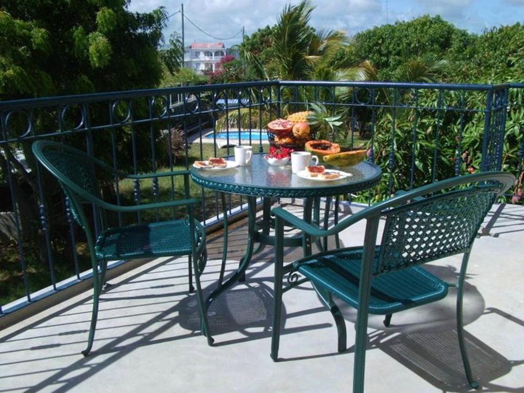 a table and chairs with food on a balcony at 2 bedrooms appartement with shared pool enclosed garden and wifi at Grande Gaube 1 km away from the beach in Grand Gaube