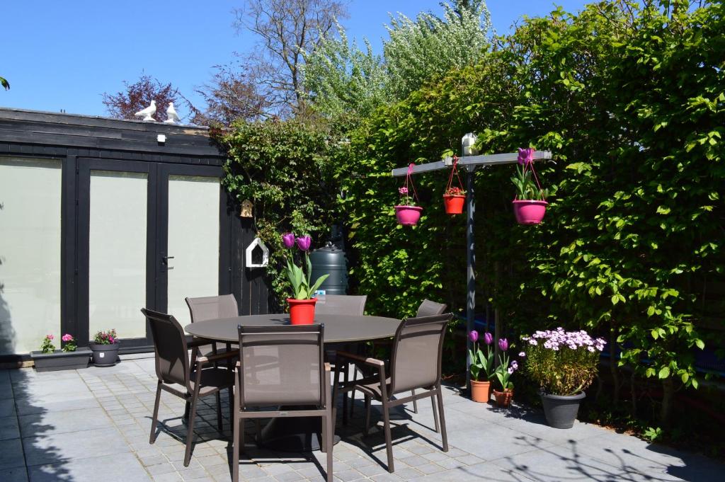 a patio with a table and chairs and plants at Casa Camino in Bruges