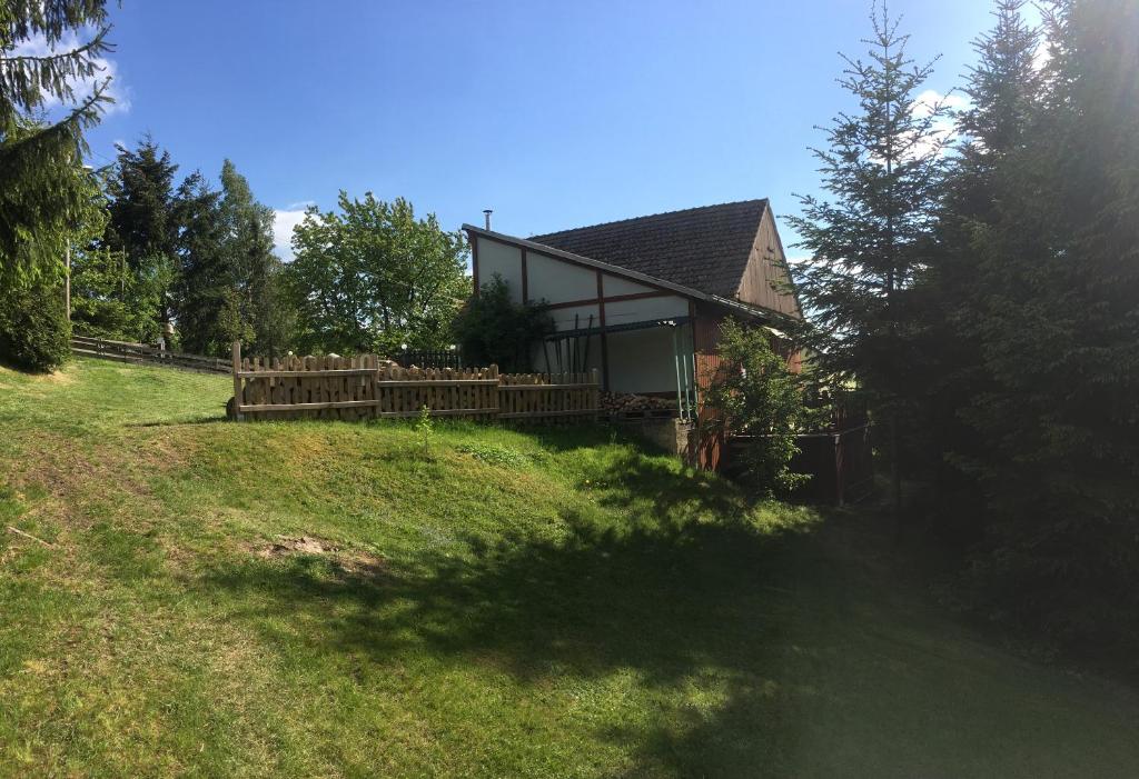 a house on a grassy hill with a yard at Ferienwohnung Magdalena in Hohnstein