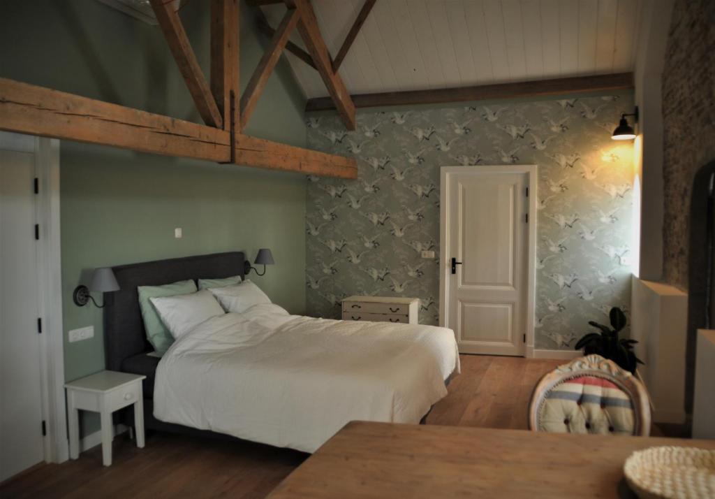 um quarto com uma cama grande e uma mesa em Bed & Brood De Vogelpoel em Wijk bij Duurstede
