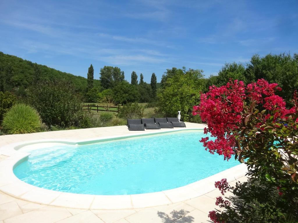 - une piscine avec 2 chaises longues et des fleurs dans l'établissement Villa de 4 chambres avec piscine privee jardin amenage et wifi a Leobard, à Léobard