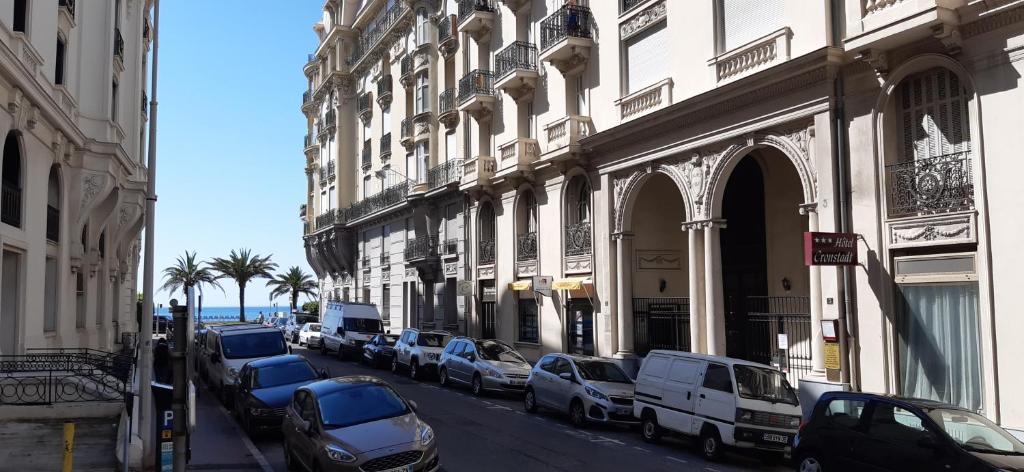 a street with cars parked next to buildings and the ocean at Large beautiful studio near the NEGRESCO HOTEL in Nice