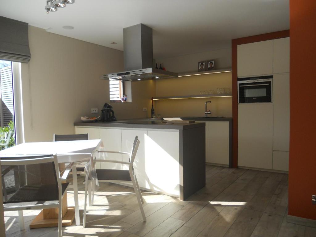 a kitchen with a table and a table and chairs at Au Paradis Guesthouse in Waregem