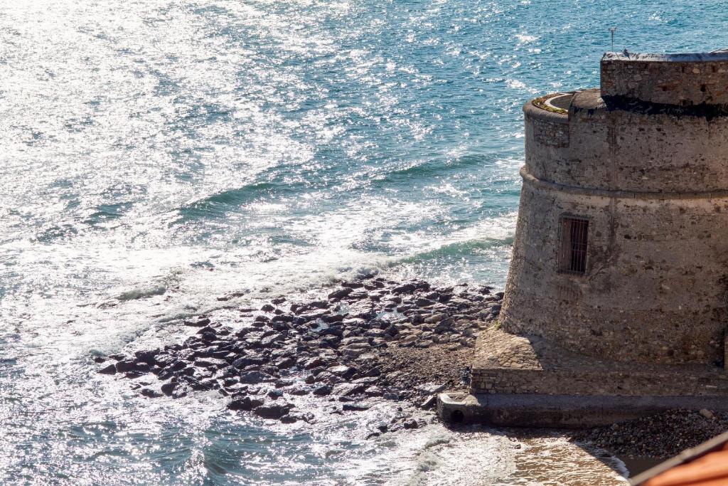 un edificio vicino all'oceano con l'acqua di Hotel Lido ad Alassio