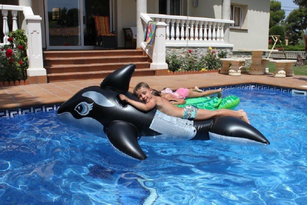 a woman riding a dolphin in a swimming pool at Casa Montgò in L'Escala