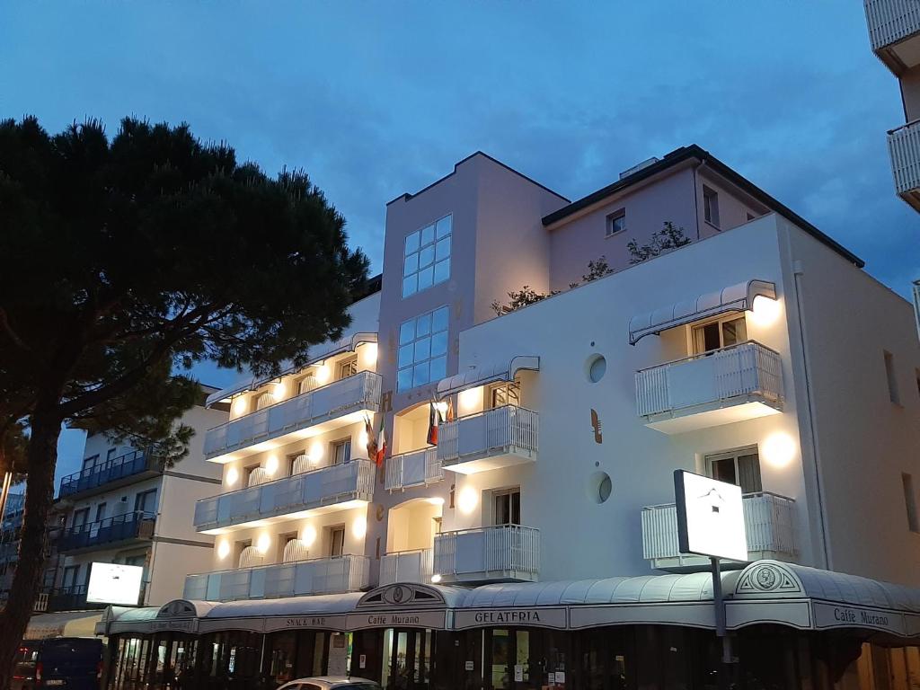 Un grand bâtiment blanc avec des lumières sur lui dans l'établissement Hotel Venezia, à Caorle