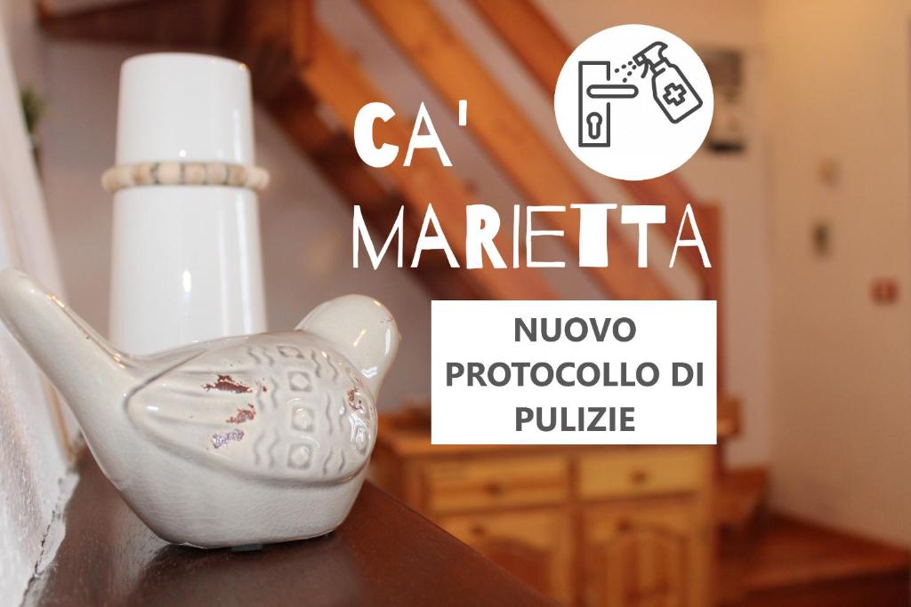a white porcelain tea pot on a table with thema materia logo at Ca' Marietta al Centro Storico in Borno