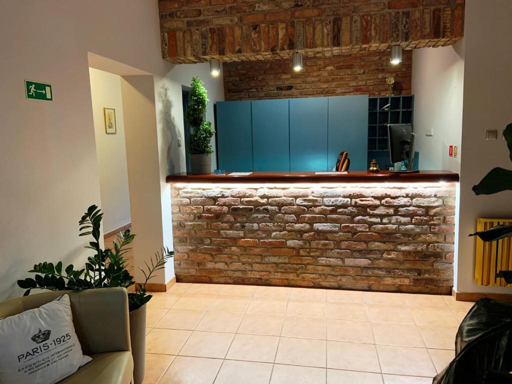 a kitchen with blue cabinets and a brick wall at A&P Motel in Mikołów