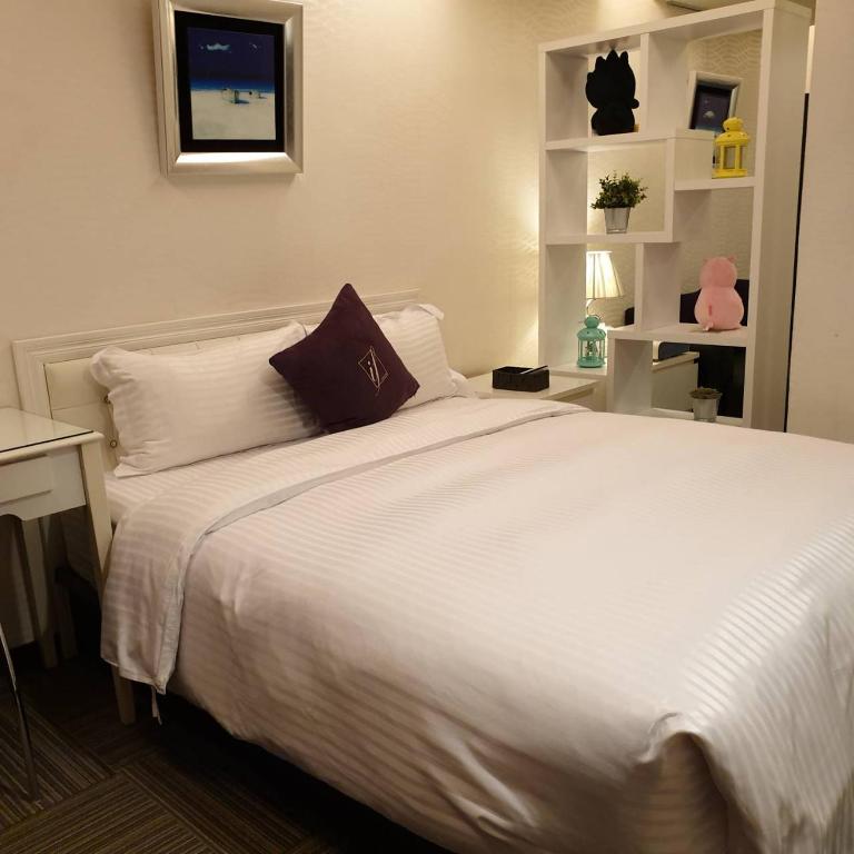a bedroom with a large bed with white sheets at 意芙旅店 Ifinn Hotel in Taipei