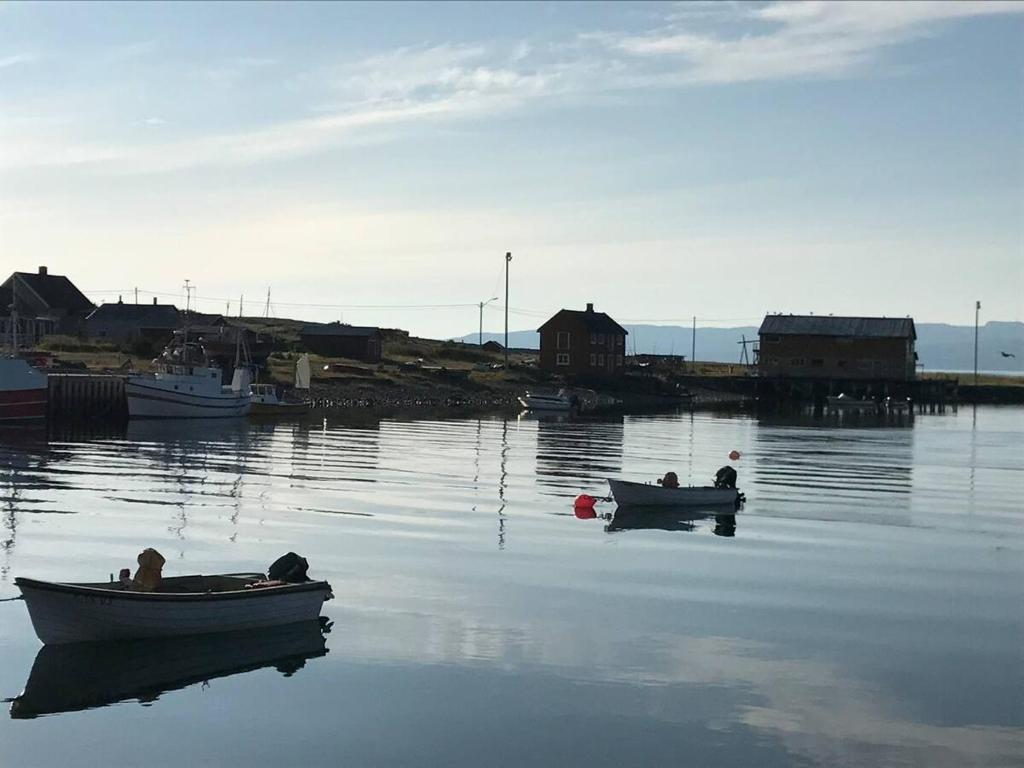 drie mensen in boten op een lichaam van water bij Jakobselvkaia in Vadsø