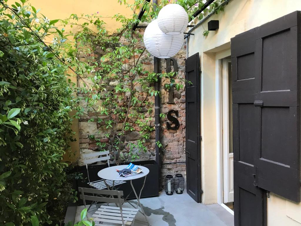 un patio con una mesa y una pared de ladrillo en Dimora Tito Speri near Arena, en Verona