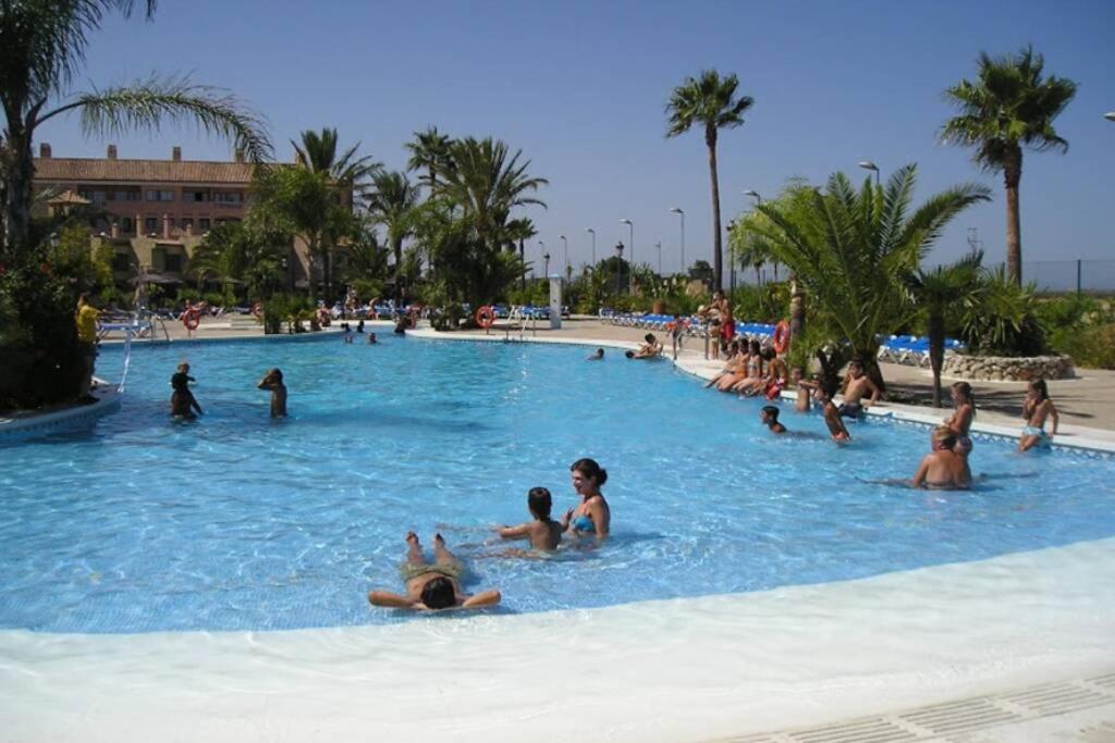 un grupo de personas nadando en una gran piscina en Duplex 6 pax con Wifi en Bahia Sur con parking y piscinas comunitarias, en San Fernando