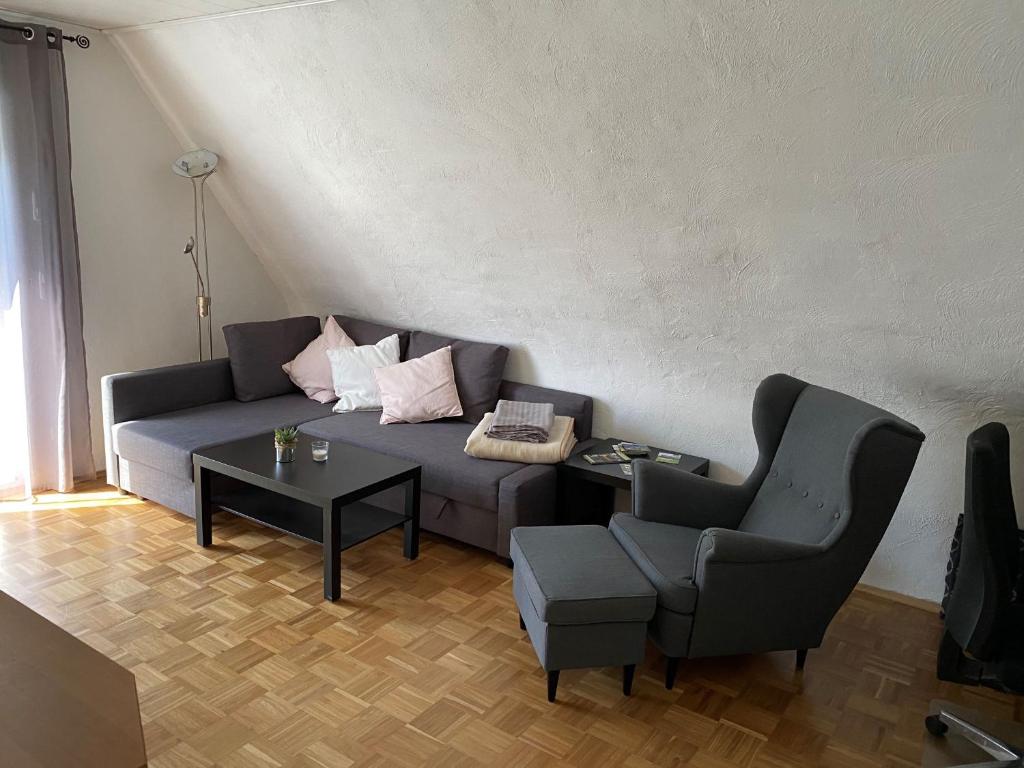 uma sala de estar com um sofá e uma cadeira em Ferienwohnungen Thingslinde em Kierspe