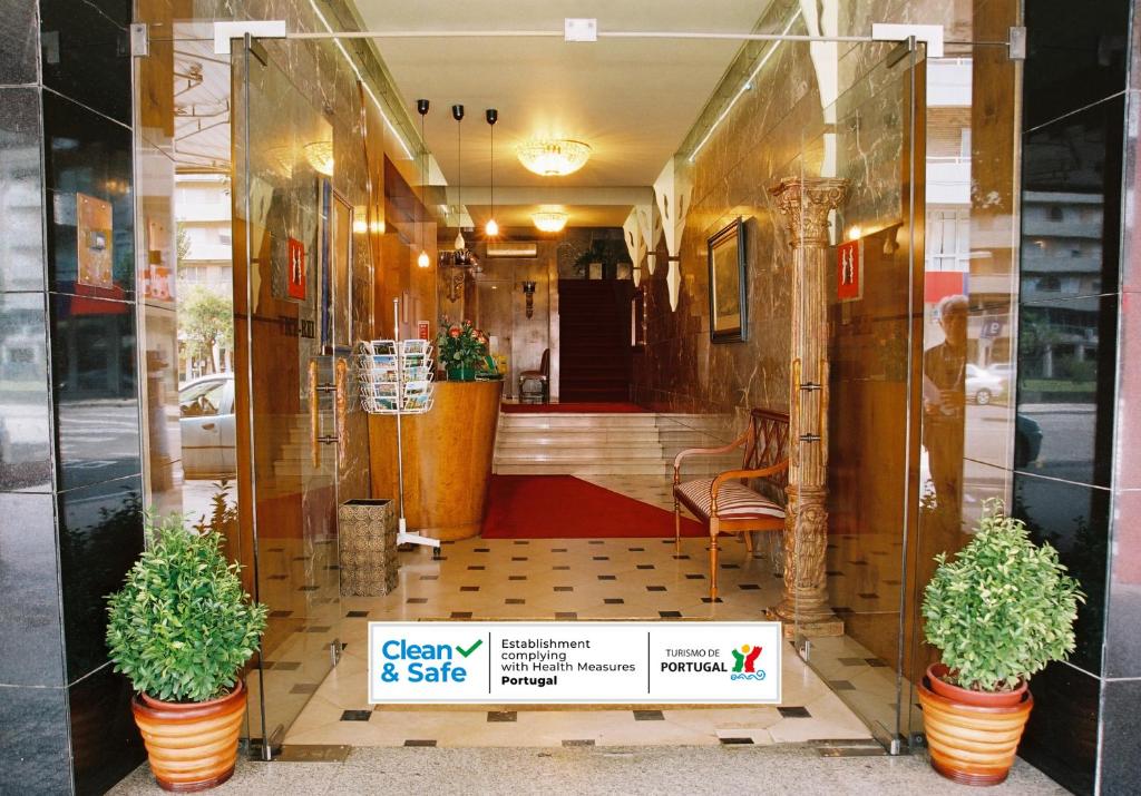 uma frente de loja com dois vasos de plantas em uma vitrine em Hotel Vice-Rei no Porto