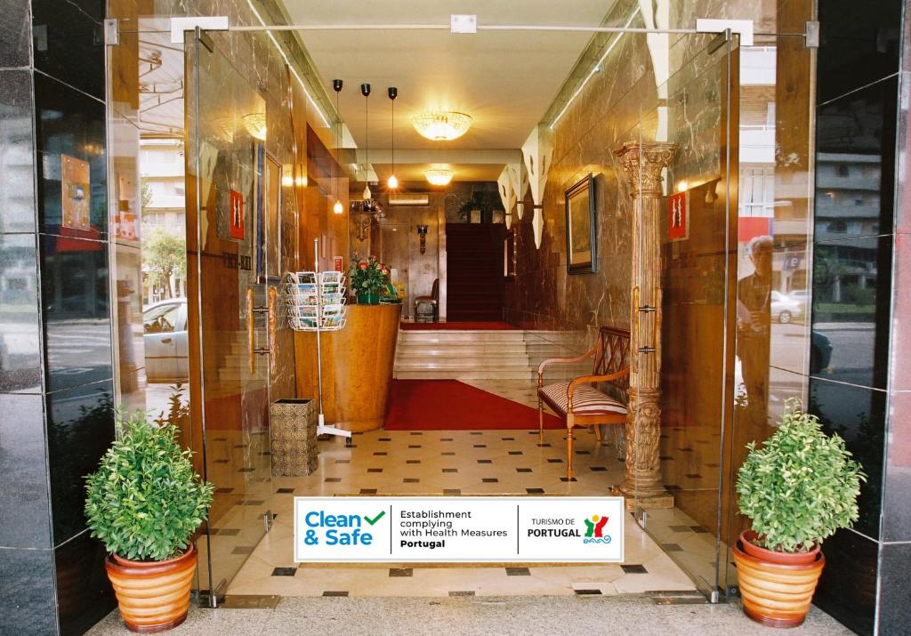 a store front with two potted plants in a store window at Hotel Vice-Rei in Porto