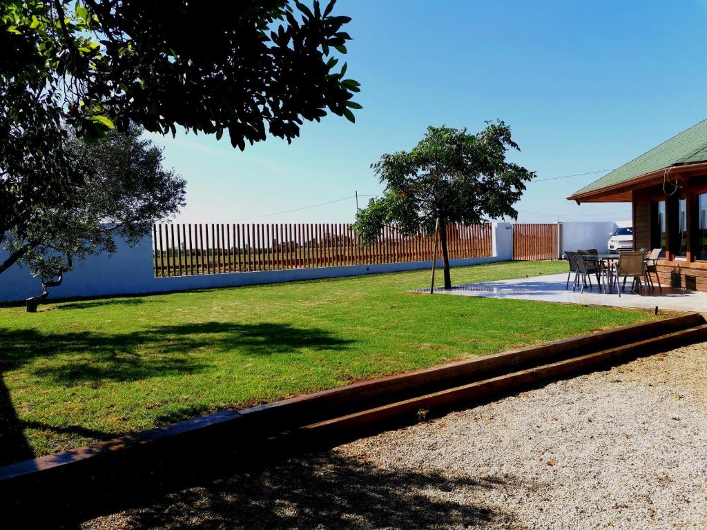 un patio con una valla, una mesa y sillas en Casita de madera, en Benicarló