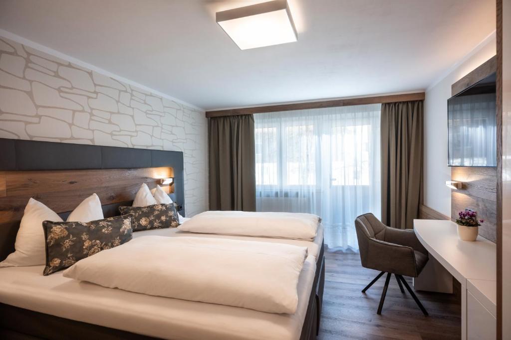 Postel nebo postele na pokoji v ubytování Hotel Baumgarten & Chalet Baumgarten