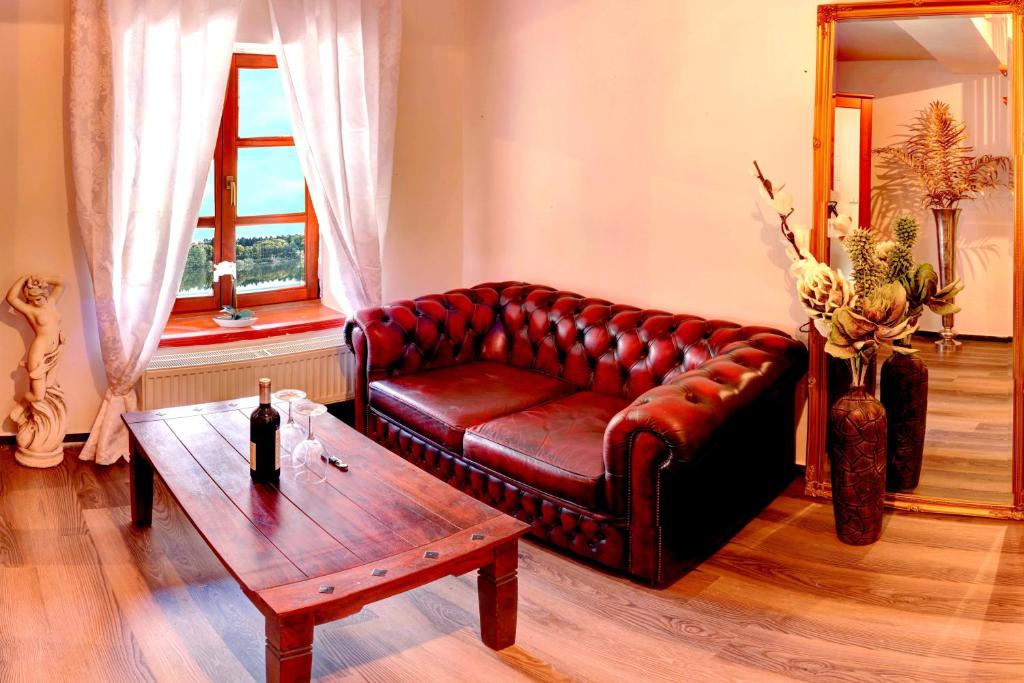 Štiřínská stodola u Prahy في Kamenice: غرفة معيشة مع أريكة جلدية وطاولة