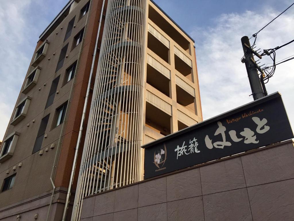 un edificio alto con un cartel delante en Hatago Hashimoto, en Ozu