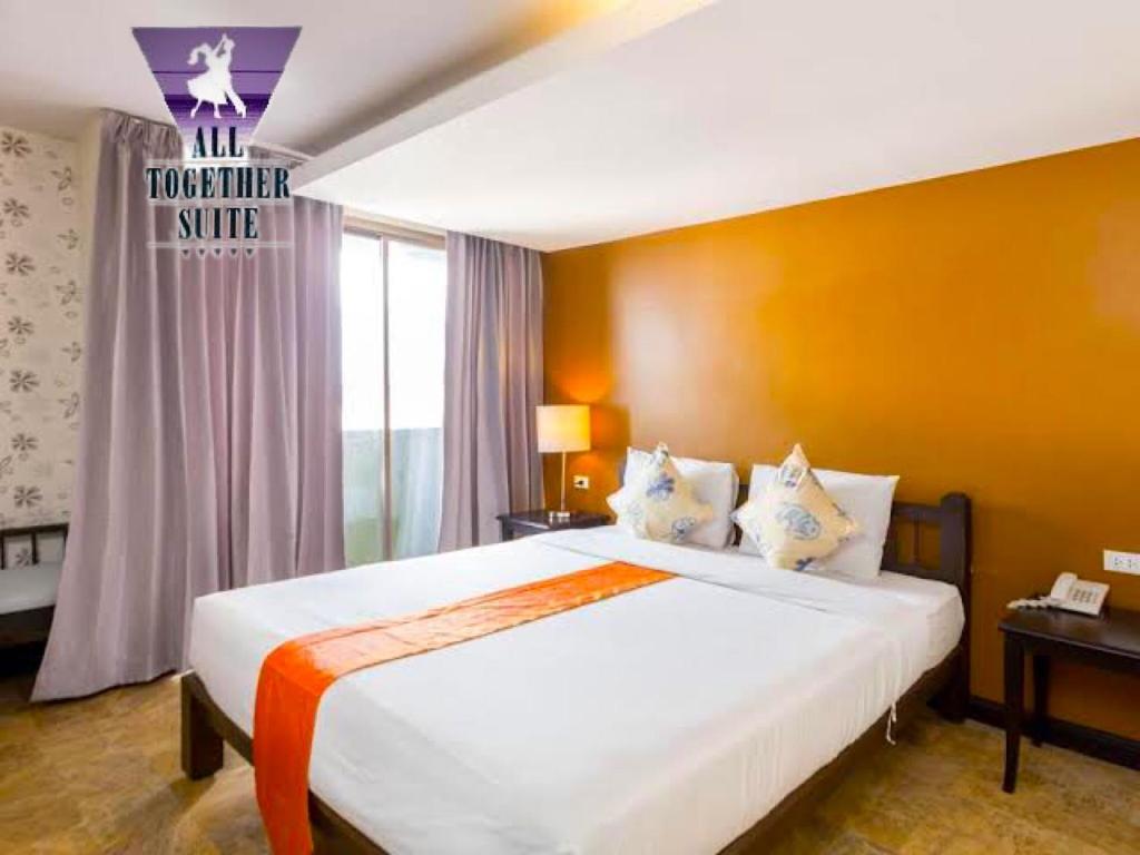 een slaapkamer met een groot wit bed in een kamer bij All Together Suite Hotel in Bangkok