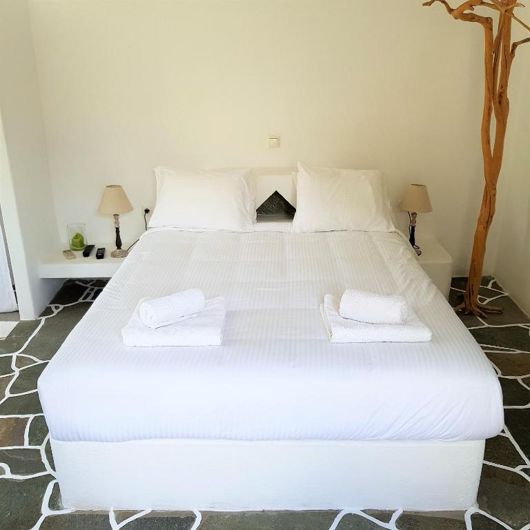 a bedroom with a large white bed with towels on it at Andromeda in Exámbela