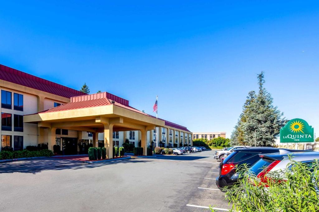 a hotel with a car parked in a parking lot at La Quinta by Wyndham Oakland Airport Coliseum in Oakland