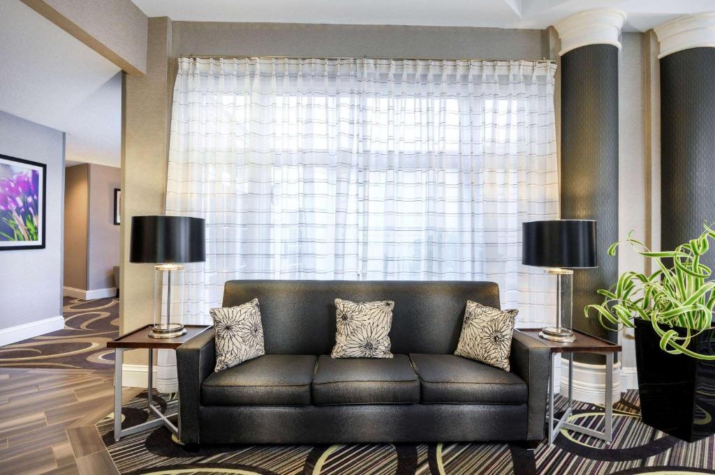 a leather couch in a living room with a large window at La Quinta by Wyndham Myrtle Beach Broadway Area in Myrtle Beach