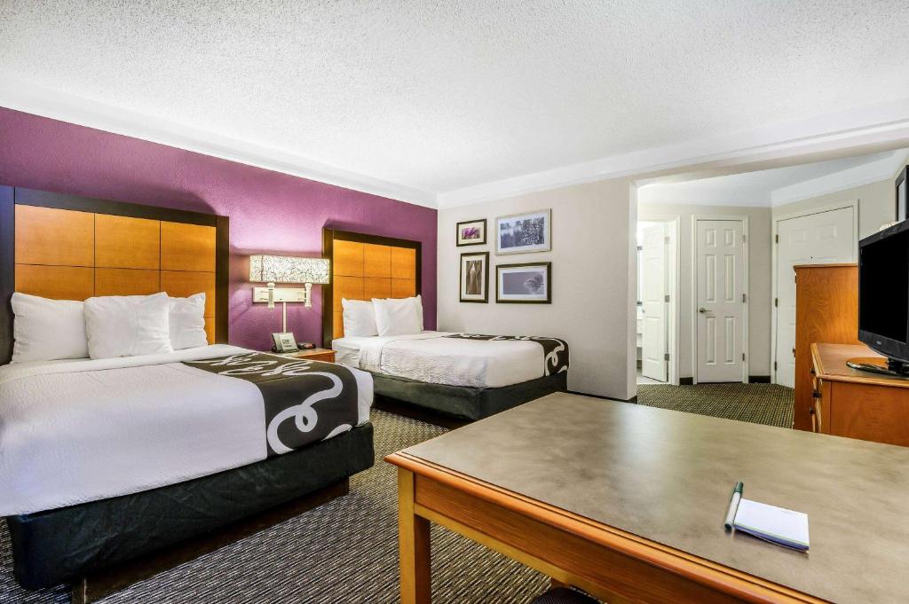 a hotel room with two beds and a table at La Quinta by Wyndham Myrtle Beach Broadway Area in Myrtle Beach
