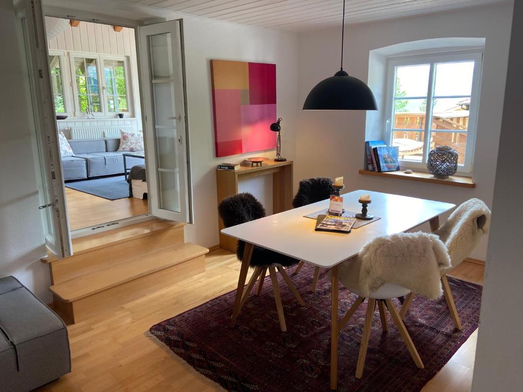 a living room with a dining room table and chairs at Apartment am Wildbach - Radeln, Wandern, Natur, Urlaub mit Hund in Fischbachau