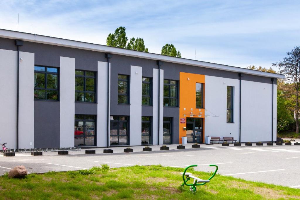 a building with a bench in the grass in front of it at Hostel Montessori in Gdańsk