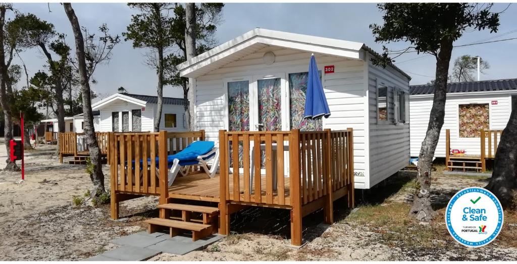 ein weißes winziges Haus mit einer großen Terrasse in der Unterkunft Mira Lodge Park in Praia de Mira