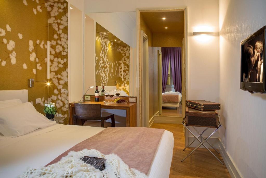 una camera d'albergo con un letto, una scrivania e una camera da letto di St. Peter Guest House a Roma