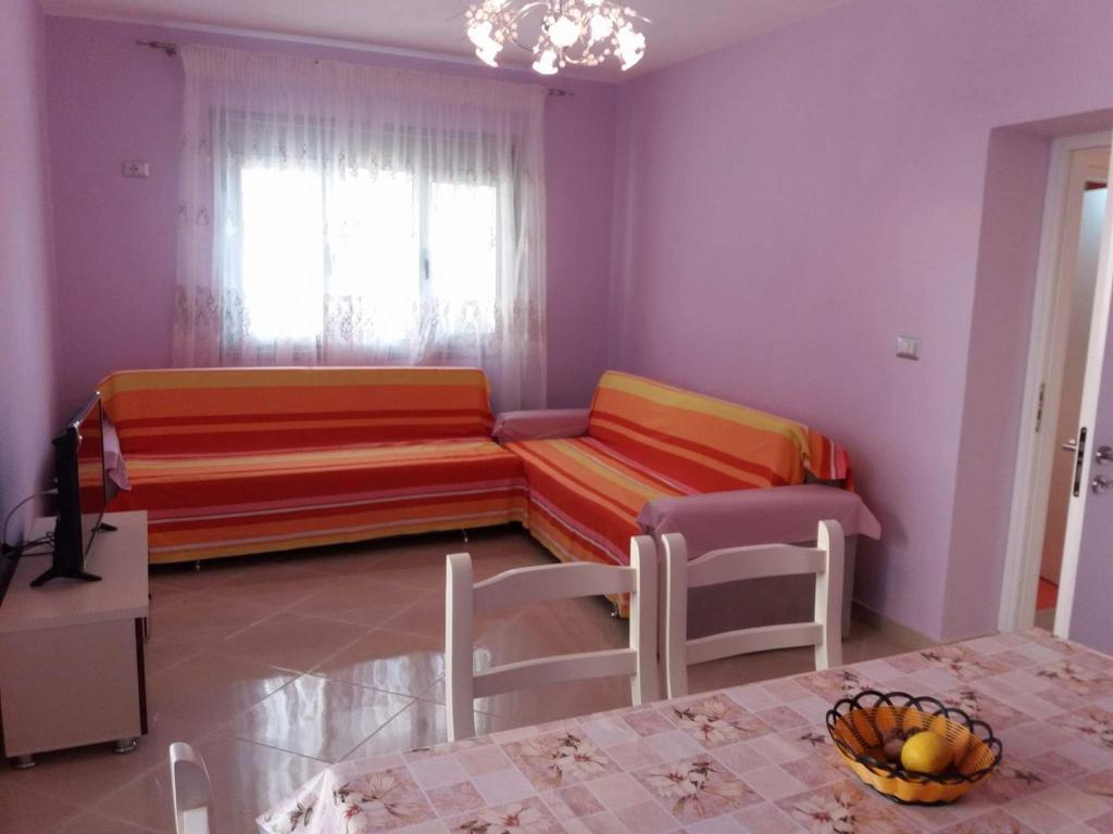 a living room with a couch and a table at Alexandra Apartament in Sarandë