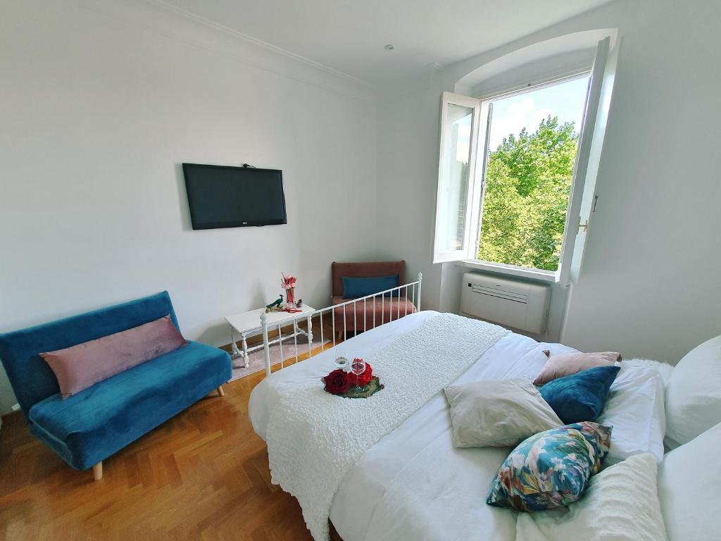 a bedroom with a bed and a couch and a window at Glory House Trastevere in Rome