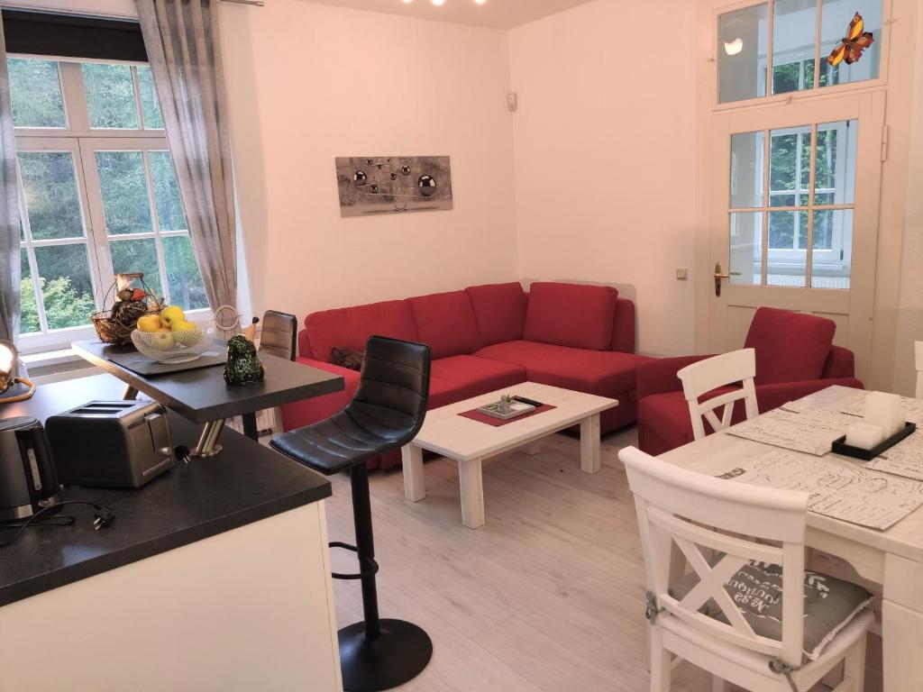 a living room with a red couch and a table at Ferienwohnung Sächsische Schweiz in Bielatal