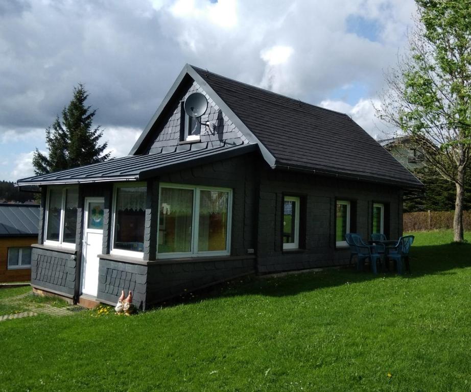 uma pequena casa a preto e branco num relvado em Ferienhaus Rennsteig Müller em Lauscha