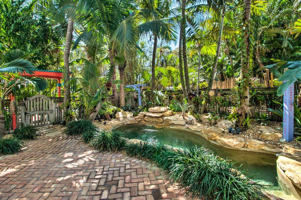 uma piscina num jardim com palmeiras em Zen Studio with Pool and Tropical Bar by Atlantic Ave em Delray Beach
