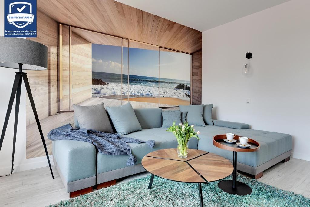 uma sala de estar com um sofá azul e uma mesa em Old Town – OldNova by Welcome Apartment em Gdansk