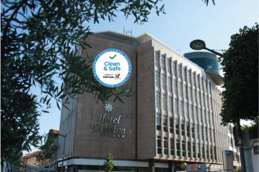 a building with a sign on the side of it at Hotel Dighton in Oliveira de Azemeis