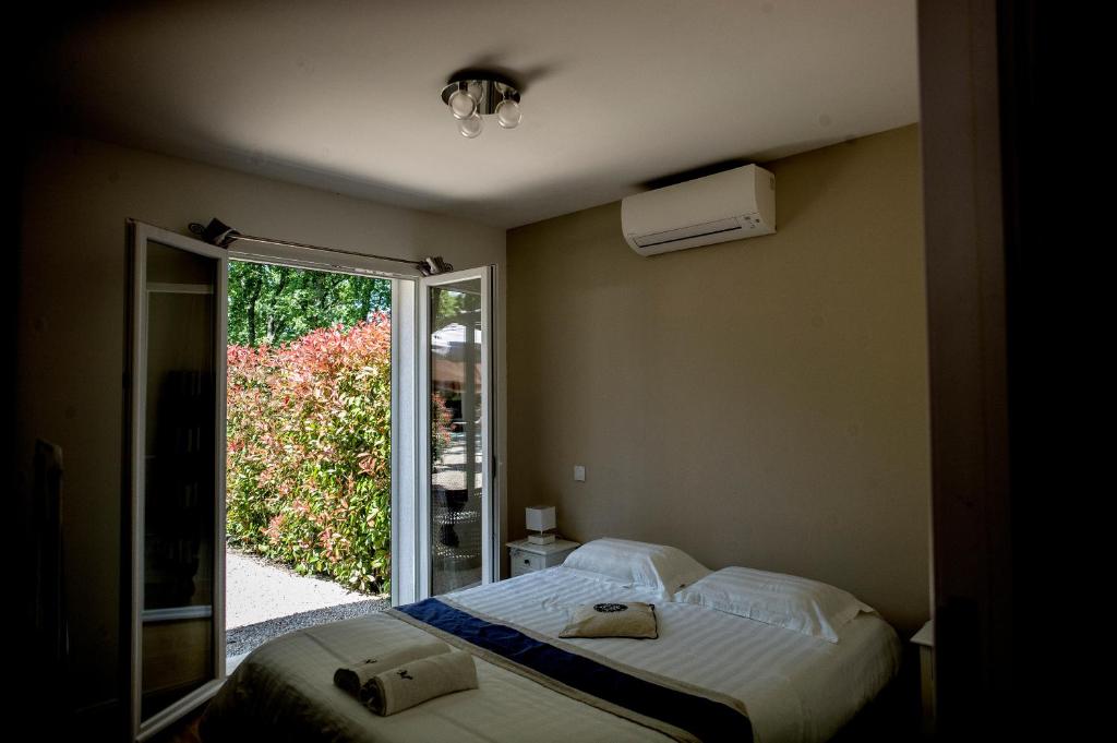 een slaapkamer met een bed en een glazen schuifdeur bij Belvillas in Montauroux