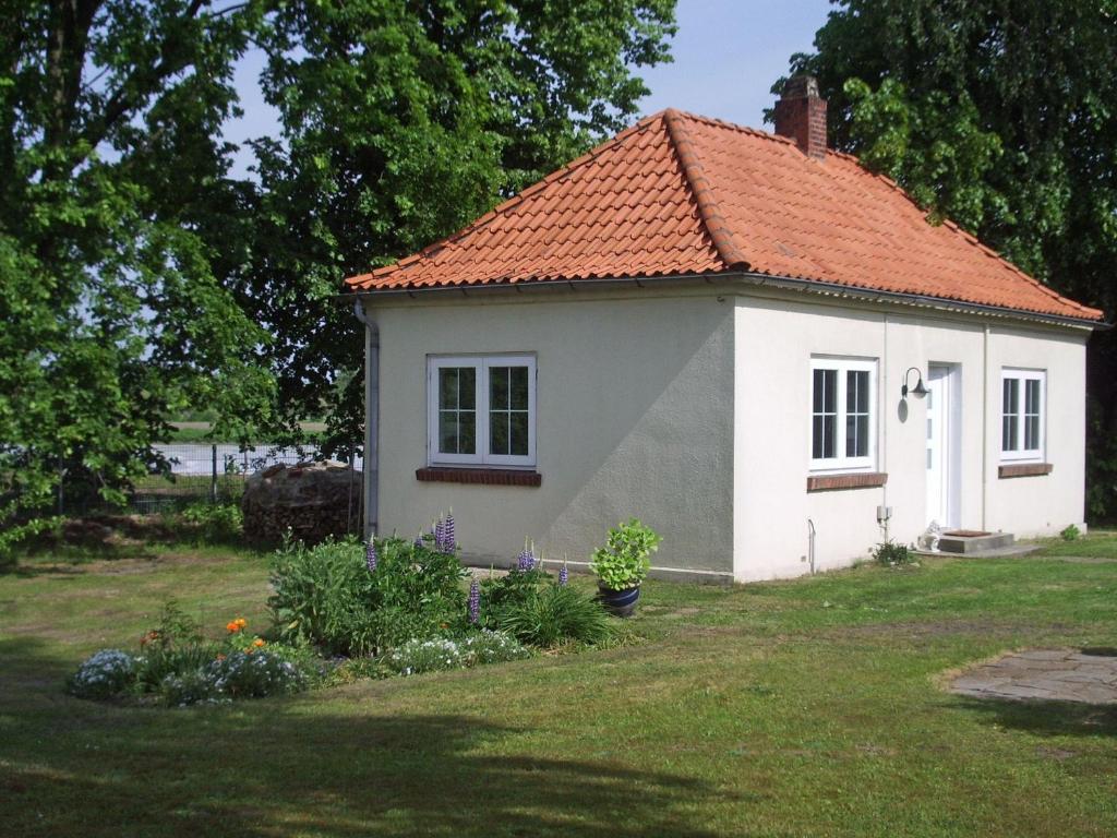mały biały dom z czerwonym dachem w obiekcie Kleines-Ferienhaus-bei-Lueneburg w mieście Bardowick