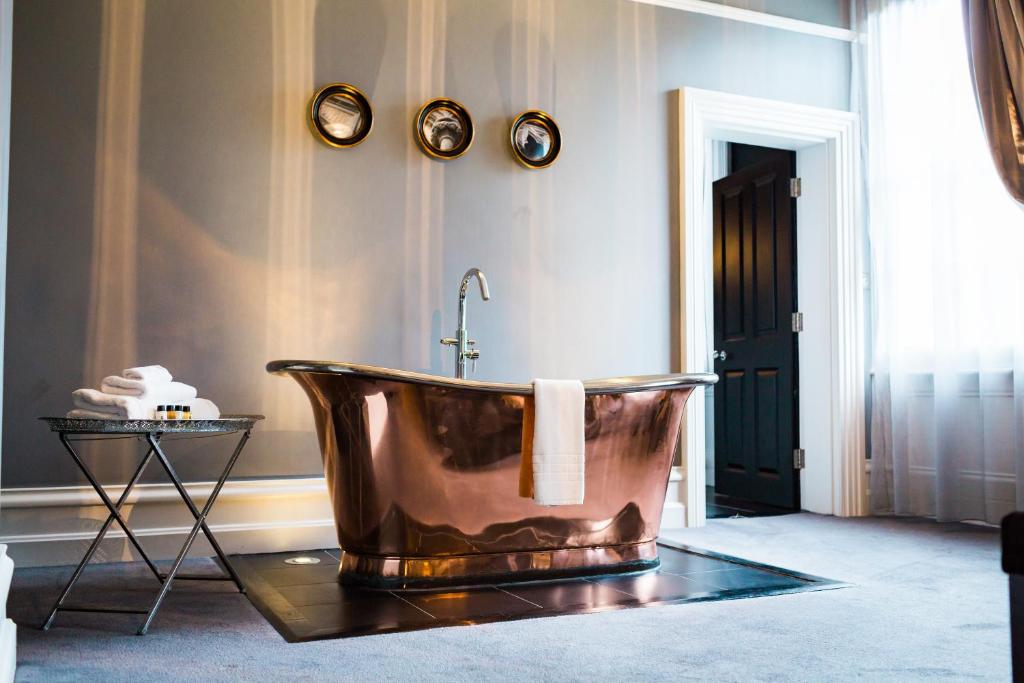 uma casa de banho com uma banheira de cobre na parede em Poets House em Ely