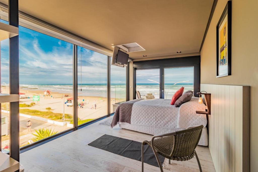 a bedroom with a bed and a view of the beach at BALUARTE POUSADA in Torres