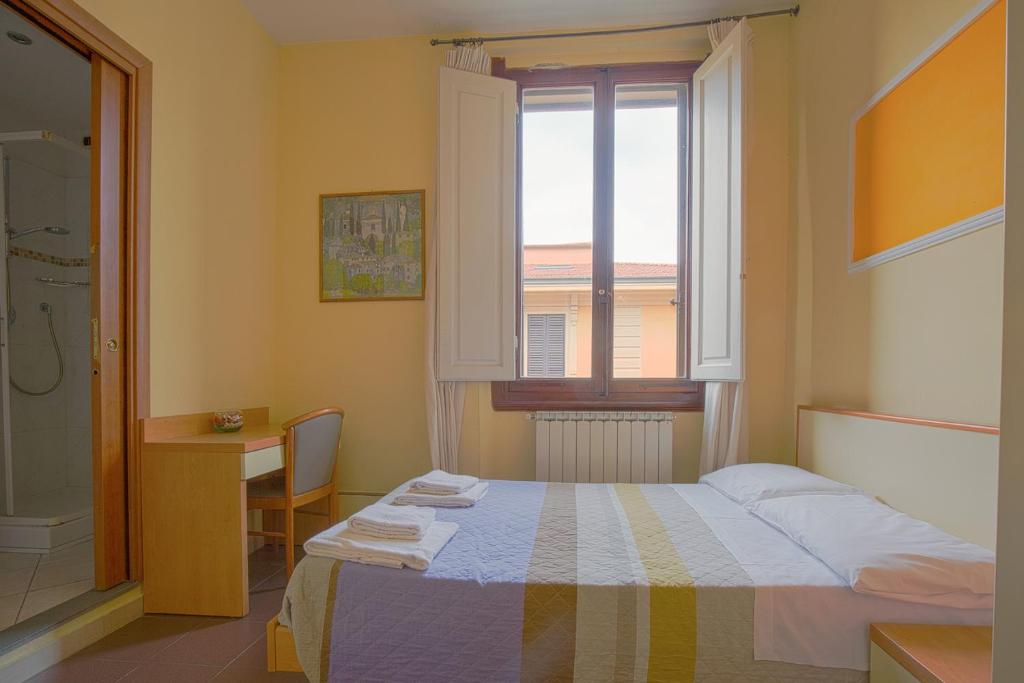 A bed or beds in a room at Hotel Angelica Firenze