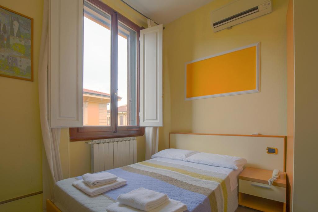 A bed or beds in a room at Hotel Angelica Firenze