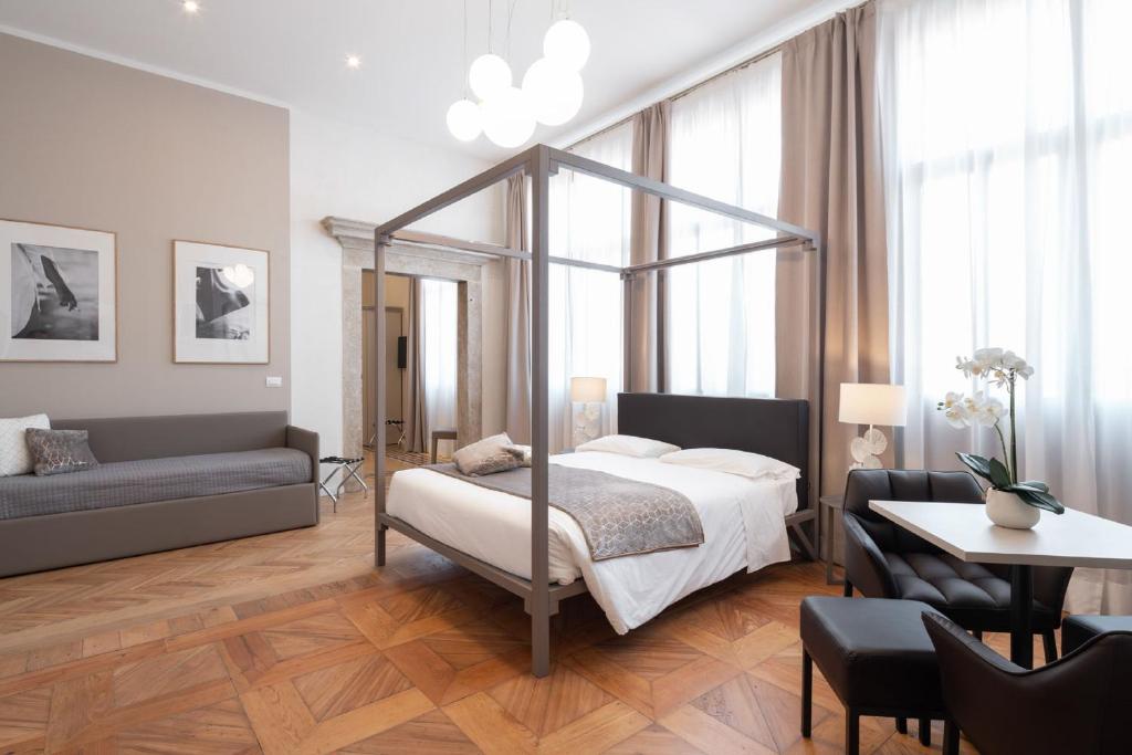 a bedroom with a bed and a table and a couch at Hotel Palazzo Martinelli Dolfin in Venice