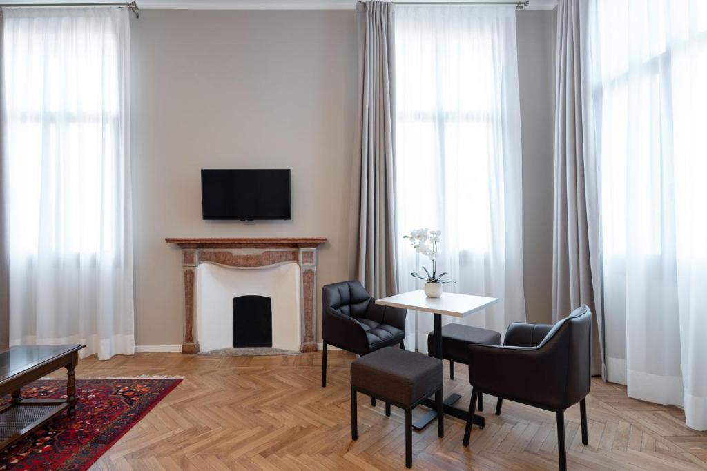 a living room with a fireplace and a table and chairs at Hotel Palazzo Martinelli Dolfin in Venice