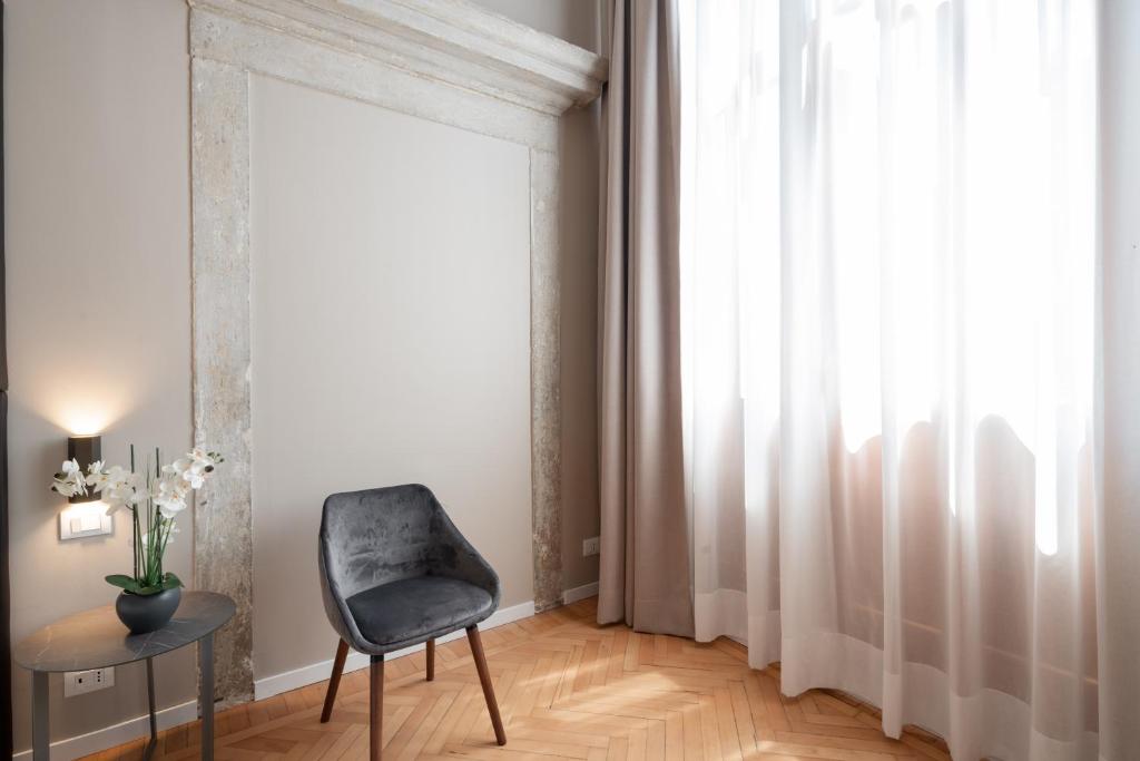 a chair and a table in a room with a window at Hotel Palazzo Martinelli Dolfin in Venice