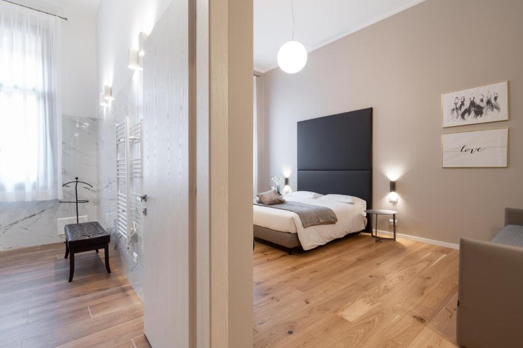 a bedroom with a bed in a white room at Hotel Palazzo Martinelli Dolfin in Venice