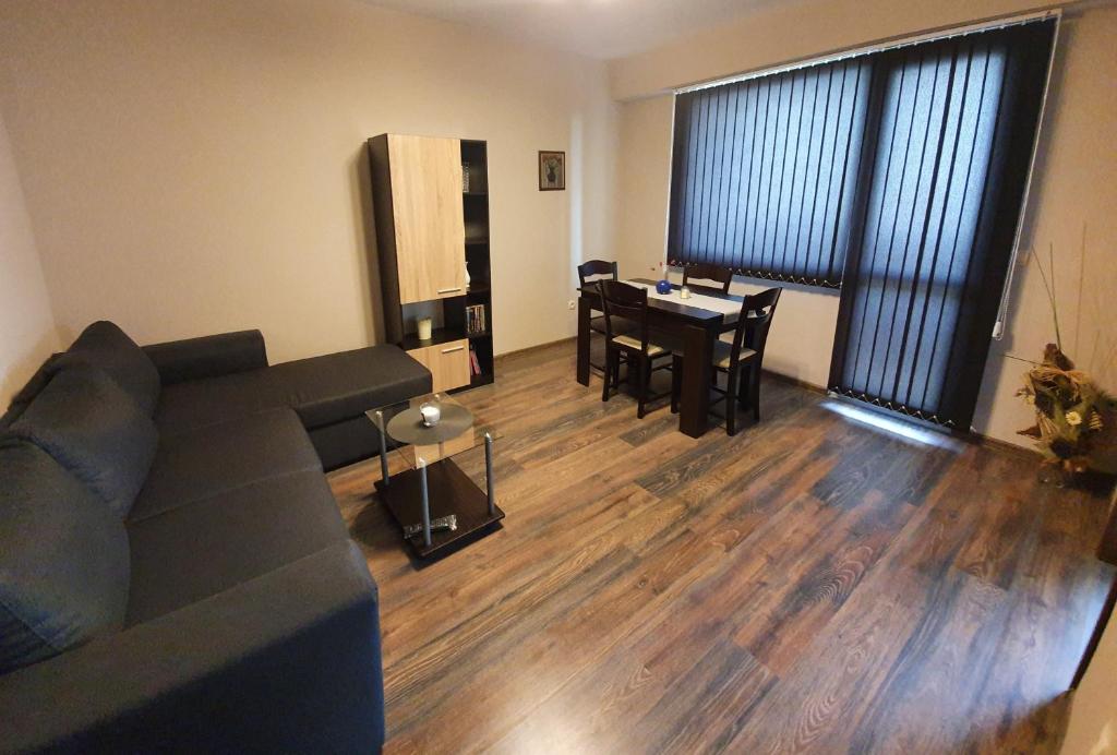uma sala de estar com um sofá e uma mesa de jantar em Апартамент БОНИТА em Haskovo